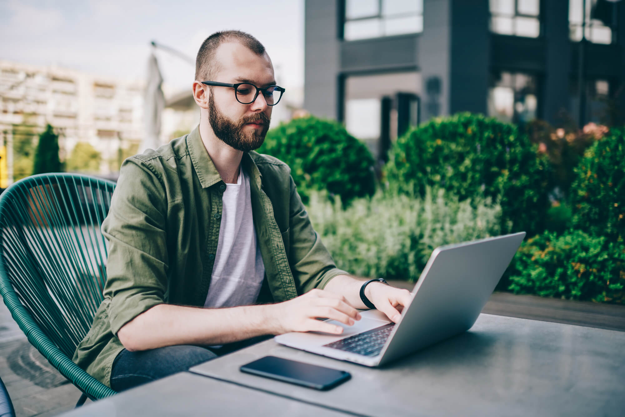 homem mexendo em notebook em local público