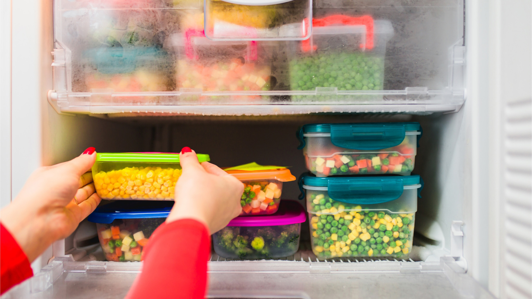 pessoa armazenando comida em freezer em potes