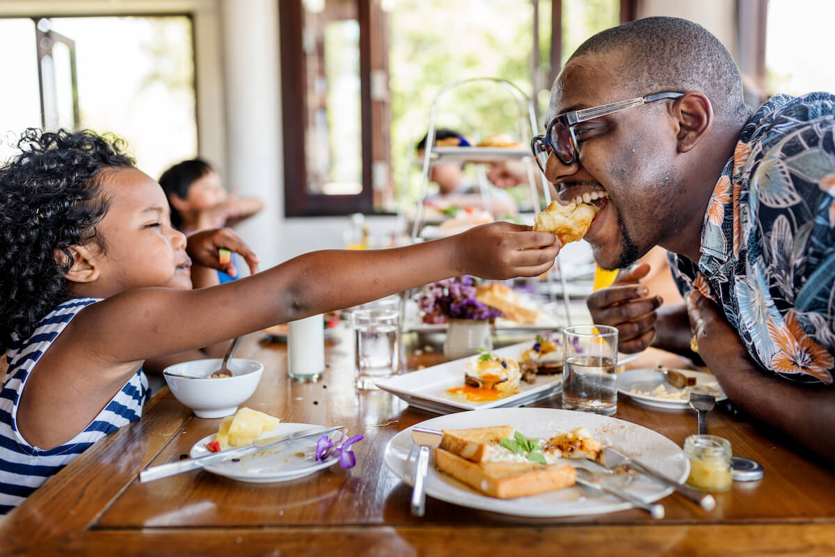 criança dando comida ao pai