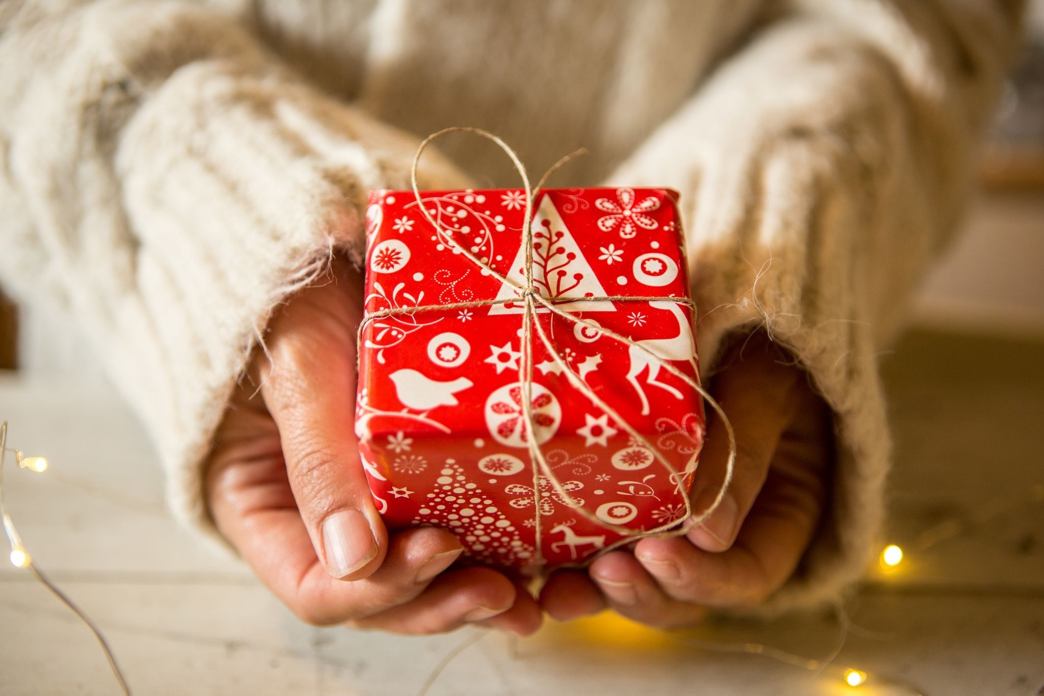 pessoa com pequeno embrulho de natal em mãos