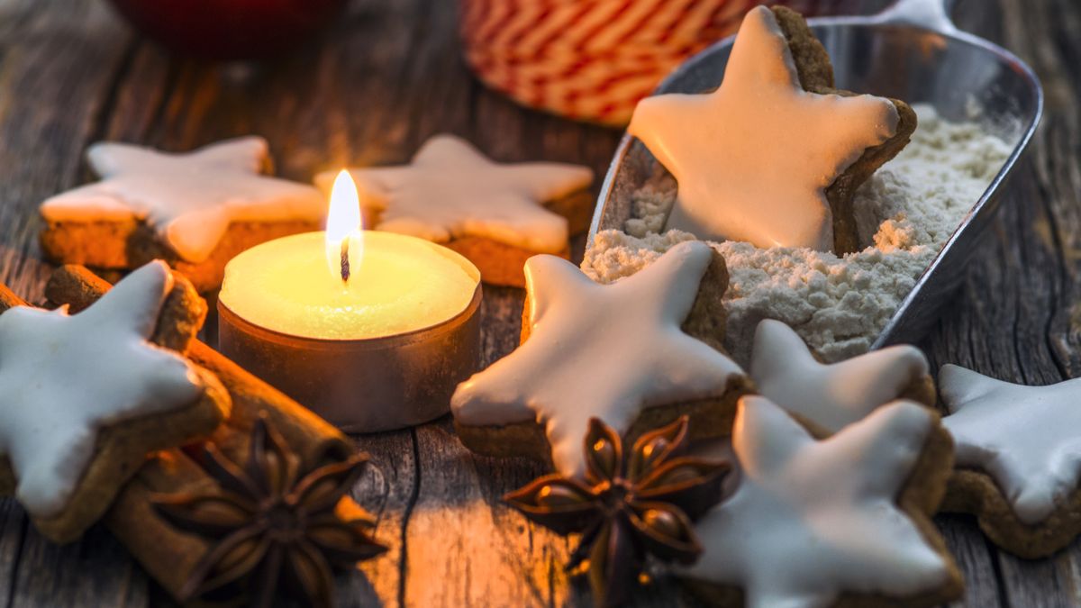 vela perto de biscoitinhos em forma de estrela de natal