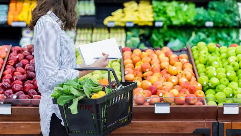 mulher fazendo compras em supermercado com lista