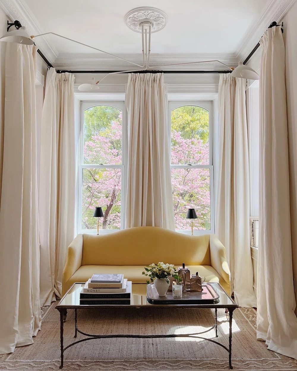 sala pequena com sofá amarelo e cortinas claras